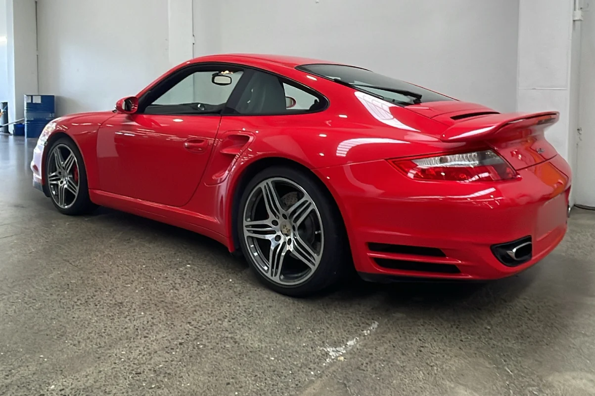 Red Porsche coupe photographed from the rear and side